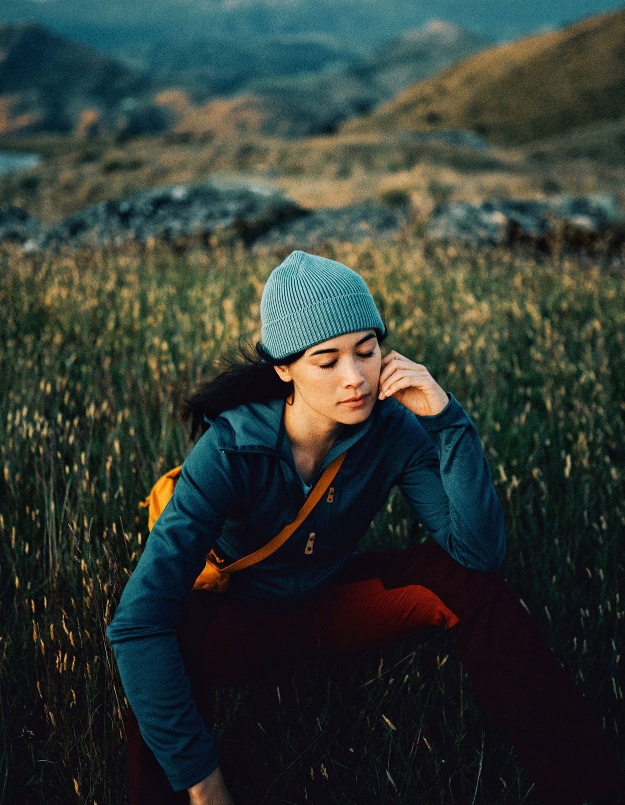 woman with beanie on standing in field