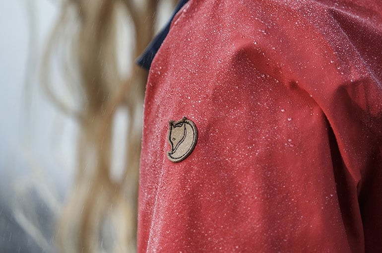 image of an the Fjallraven emblem on an eco-shell jacket with snow falling