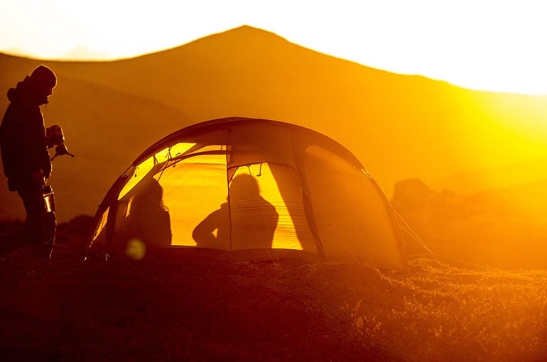 slider image of people silhouetted in a tent