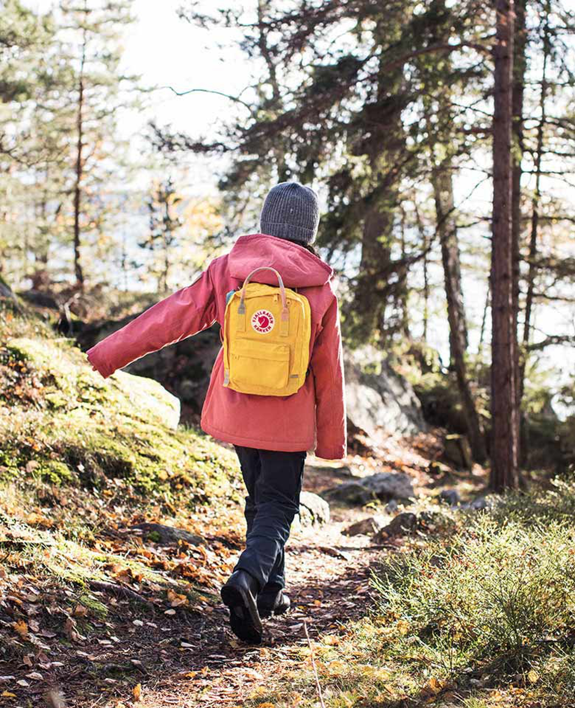 a young girl walking wearing fjallraven apparel and backpack
