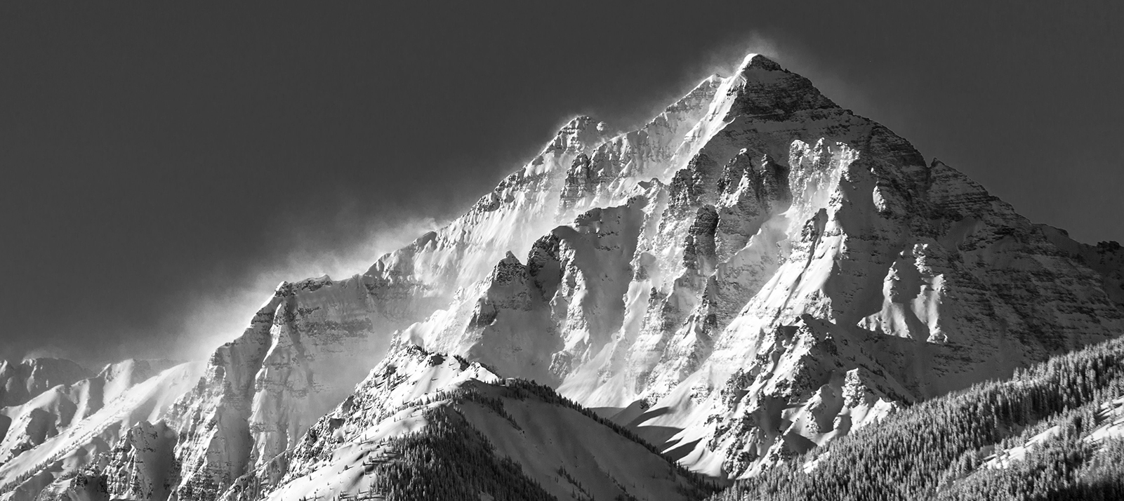 Black and white windblown snowy mountain peak.